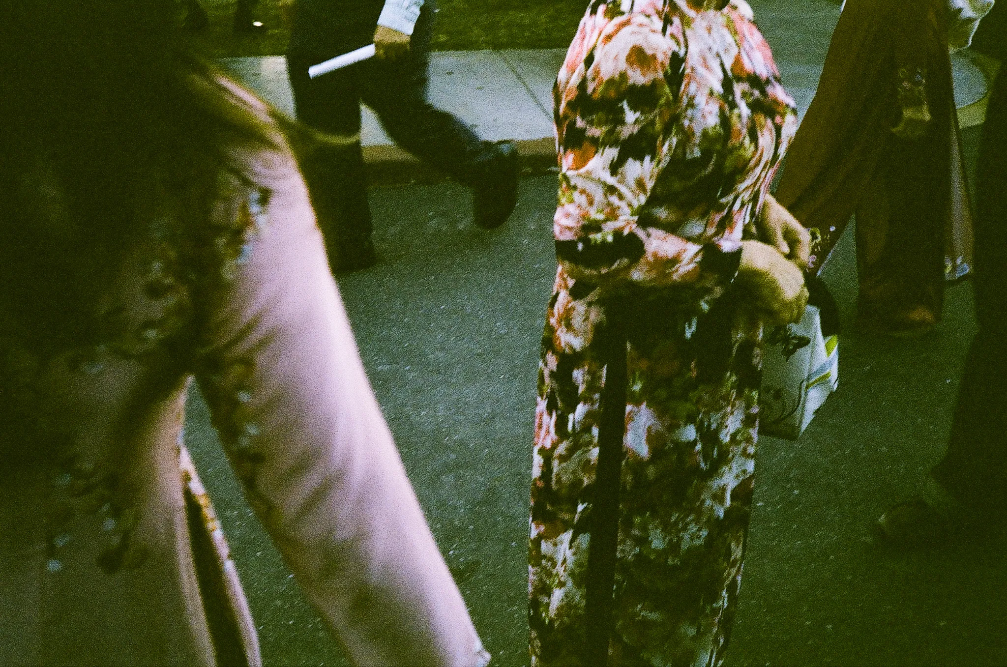 Woman in a floral áo dài photographed from behind on a city street